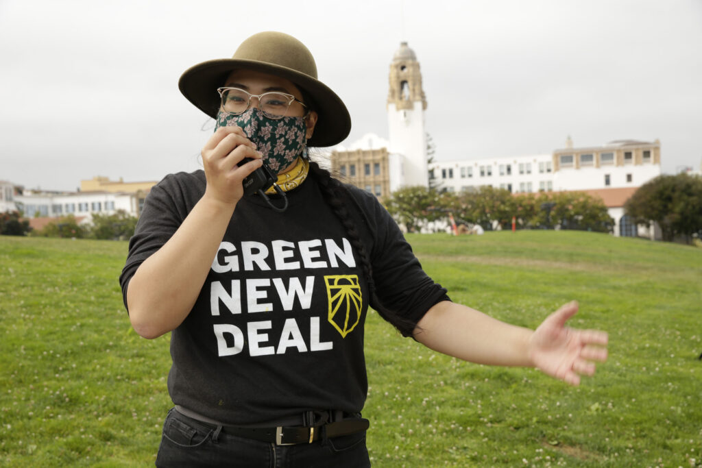 A California Green New Deal organizer hypes up a crowd through a megaphone